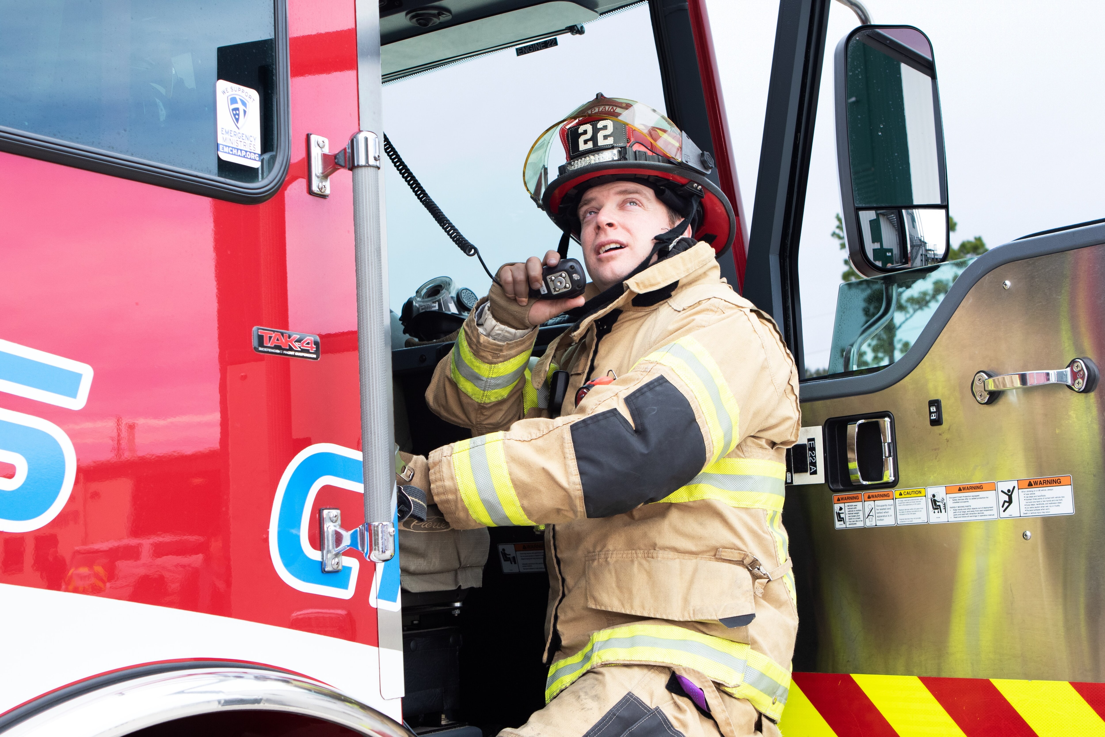 Firefighter using two-way radio at fire truck